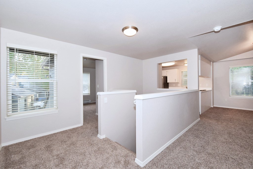 an empty living room and kitchen with a large window