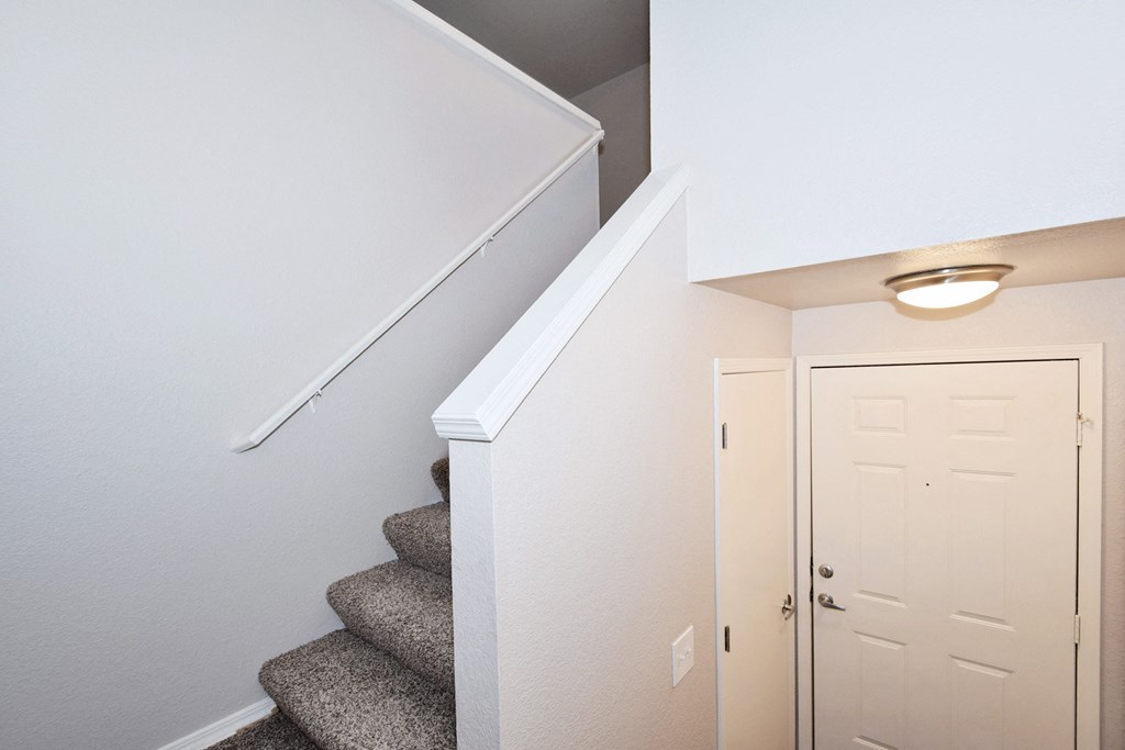 a view of a staircase in a home with a white door