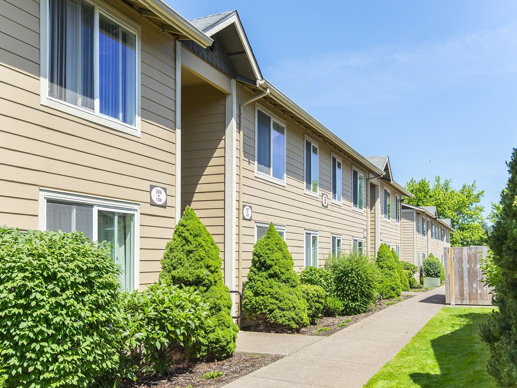 a row of houses with a sidewalk in front of them