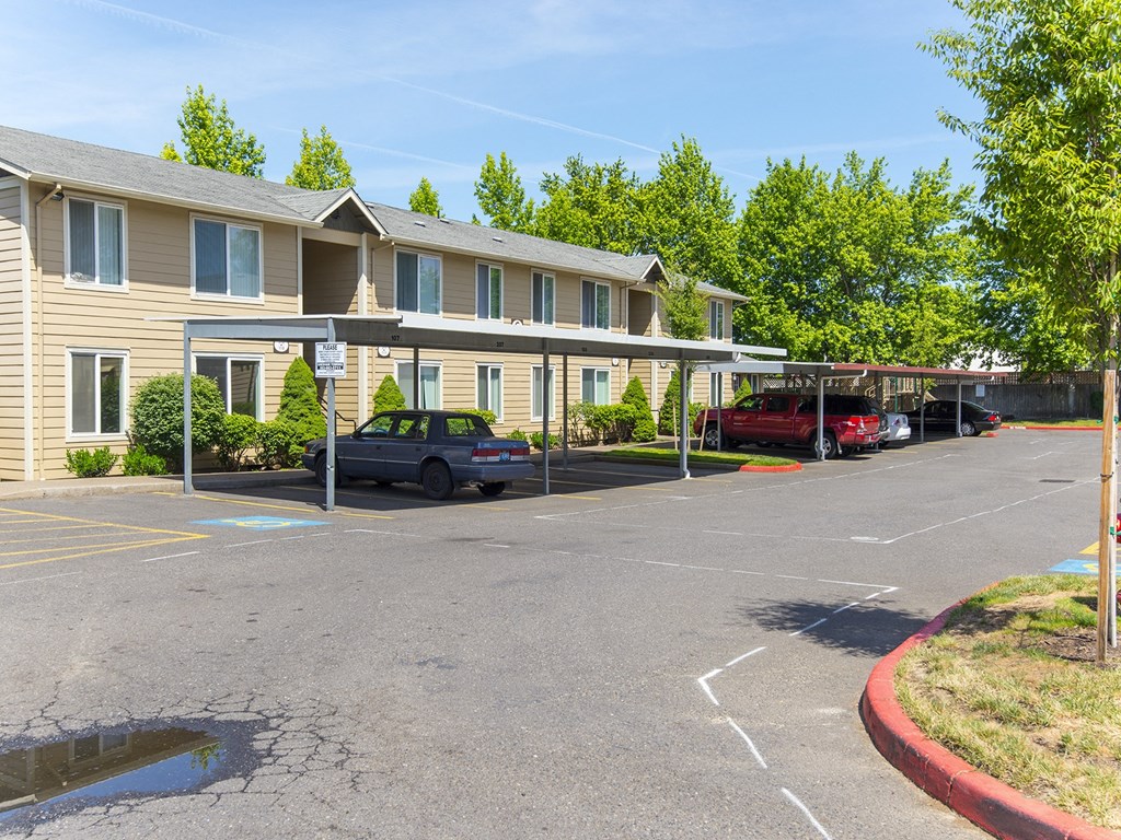 an empty parking lot in front of an apartment building