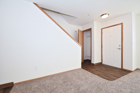 a living room with a white wall and a door to a hallway