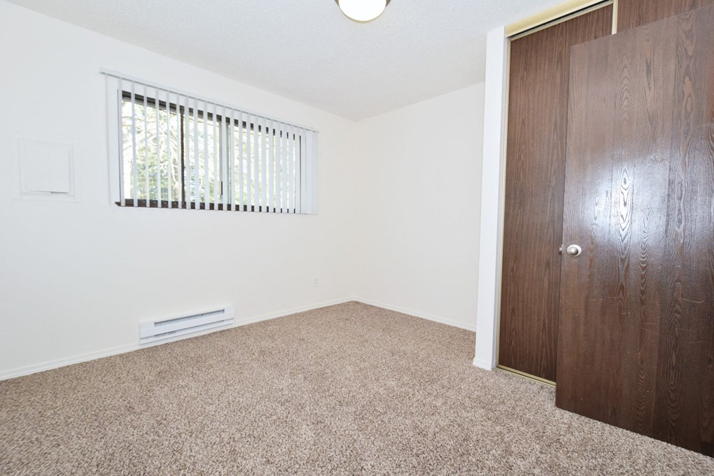 a bedroom with white walls and carpet