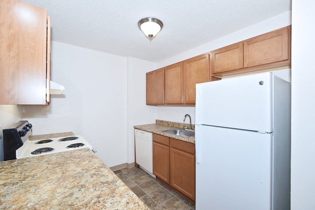 a kitchen with a white refrigerator freezer next to a stove top oven