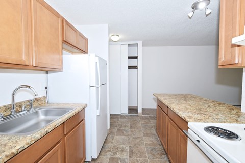 a kitchen with wooden cabinets and a sink and a refrigerator