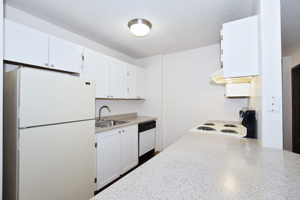a kitchen with white cabinets and a white counter top