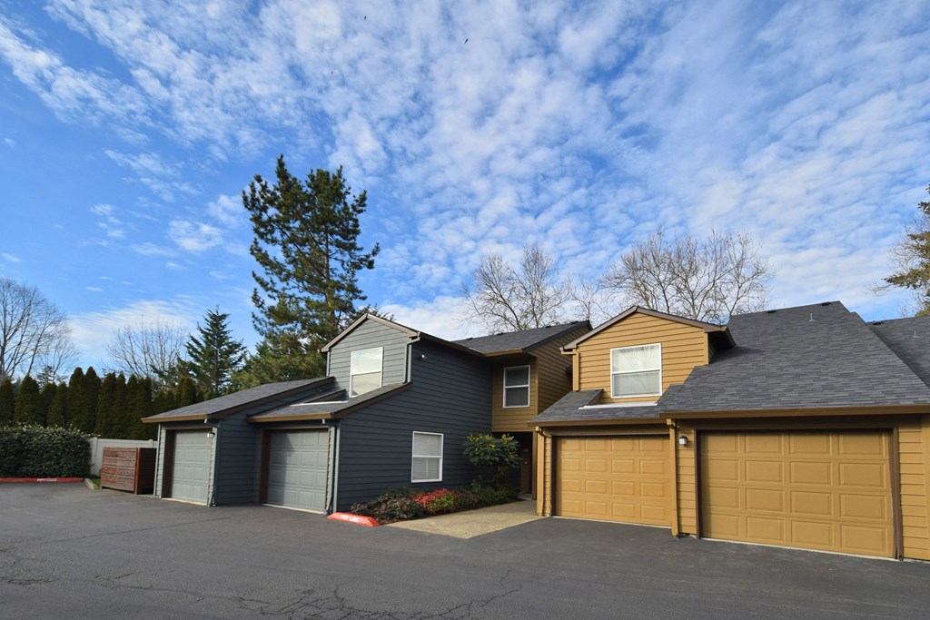 a house with a garage and a cloudy blue sky