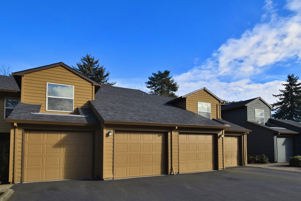 a house with a row of garage doors and a blue sky