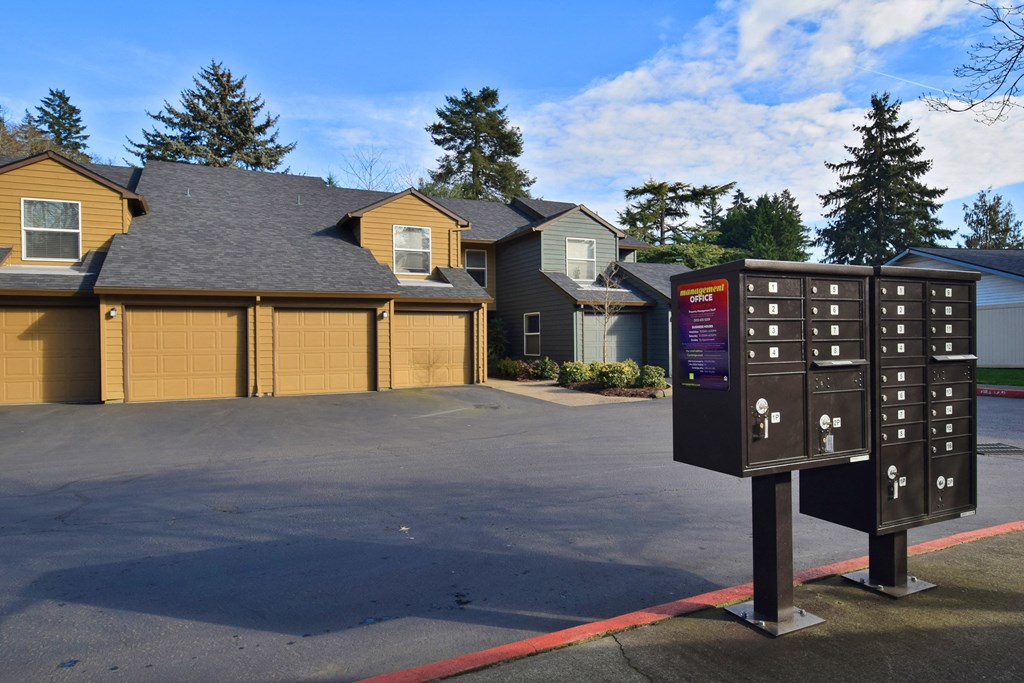 a parking lot in front of a house with a mailbox