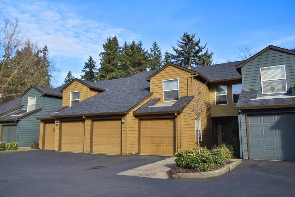 the front of a yellow house with a garage