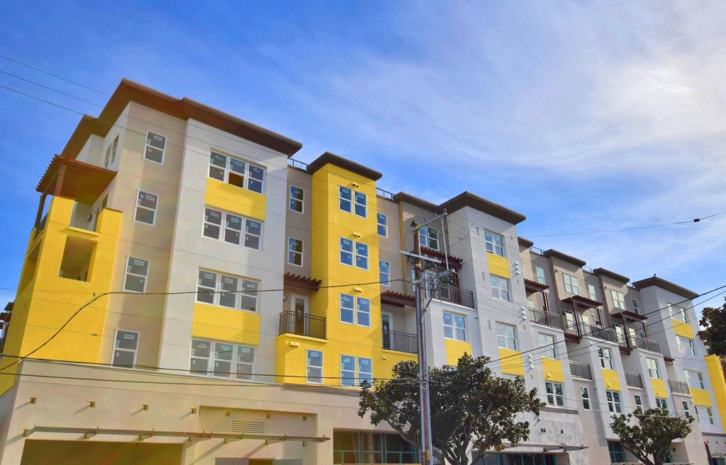 a colorful apartment building with a blue sky in the background