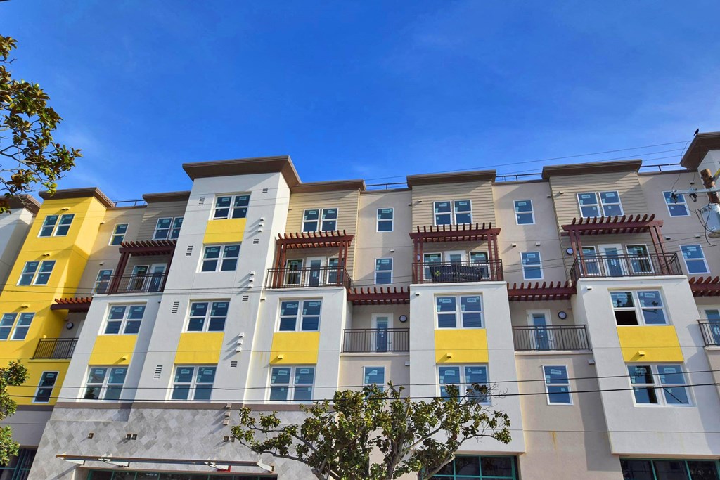 a typical apartment building with yellow and white facade
