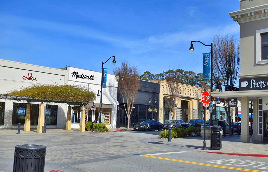 a city street with stores and a stop sign