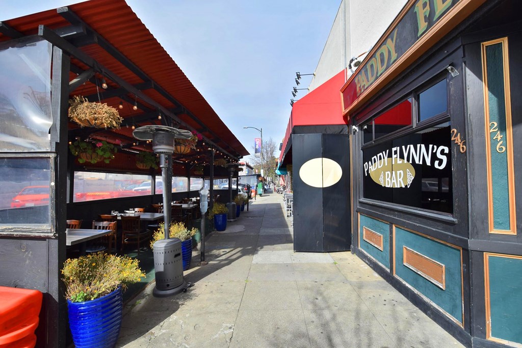 a sidewalk in front of a restaurant with a sidewalk sign in the window