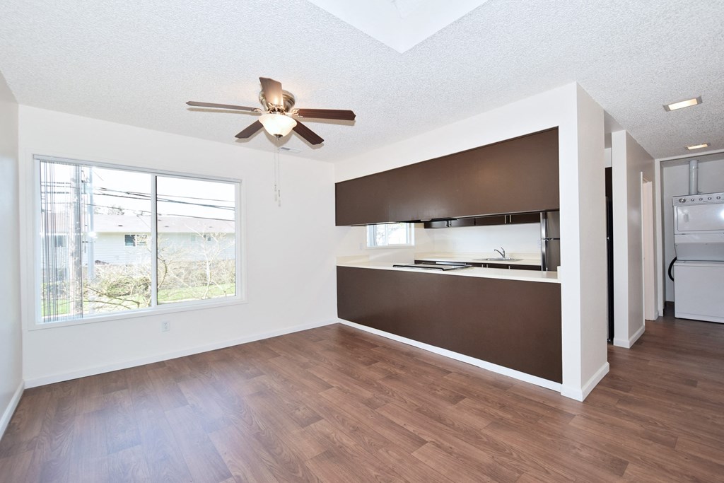 Timberwood Beaverton:  an empty living room with a large window and a ceiling fan