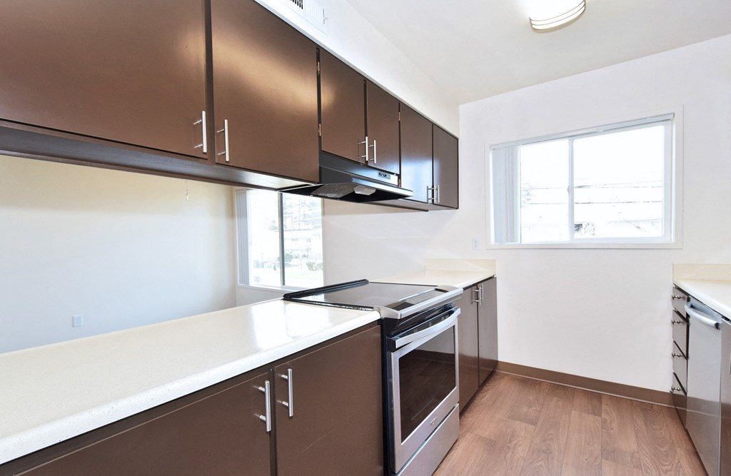 Timberwood Beaverton:  a kitchen with white countertops and brown cabinets