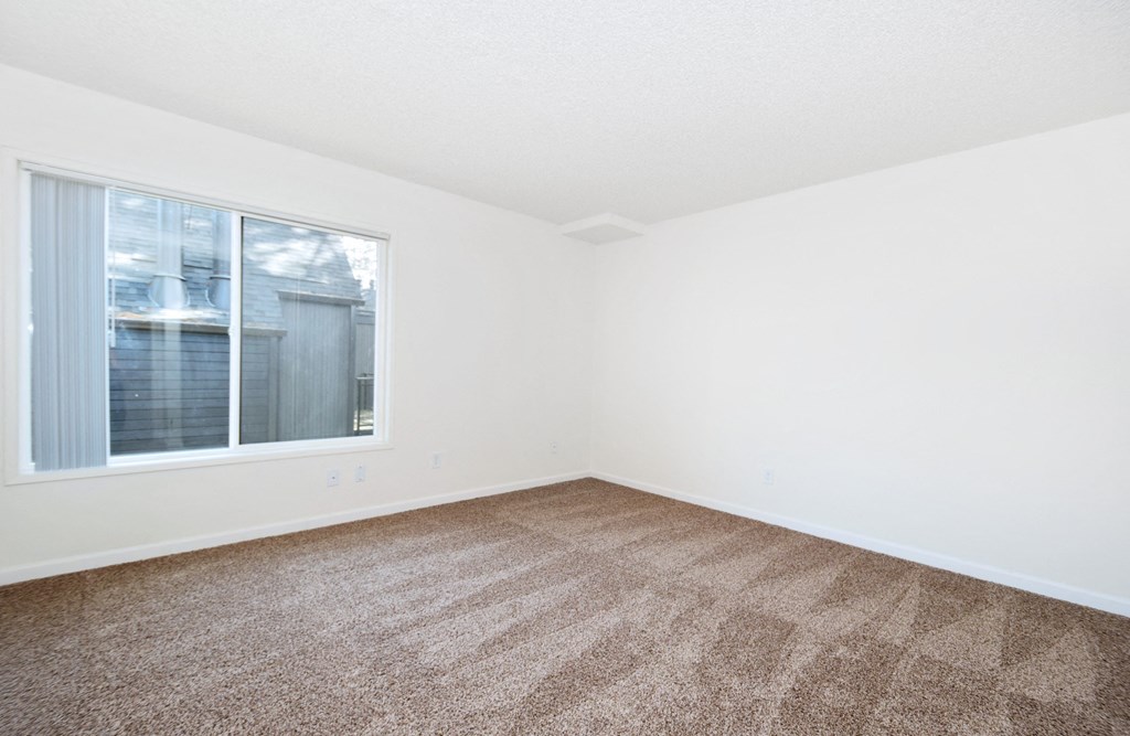 Timberwood Beaverton: a bedroom with a large window and a carpeted floor