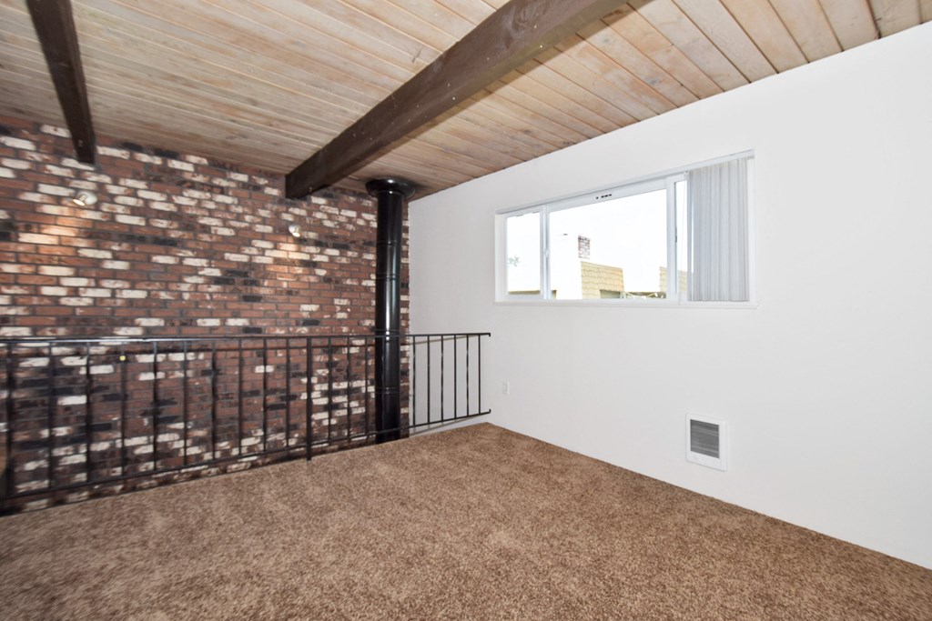 a loft with a brick wall and a window