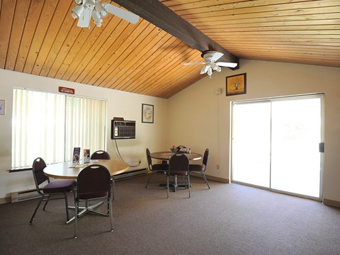 A room with a wooden ceiling and a table with chairs.