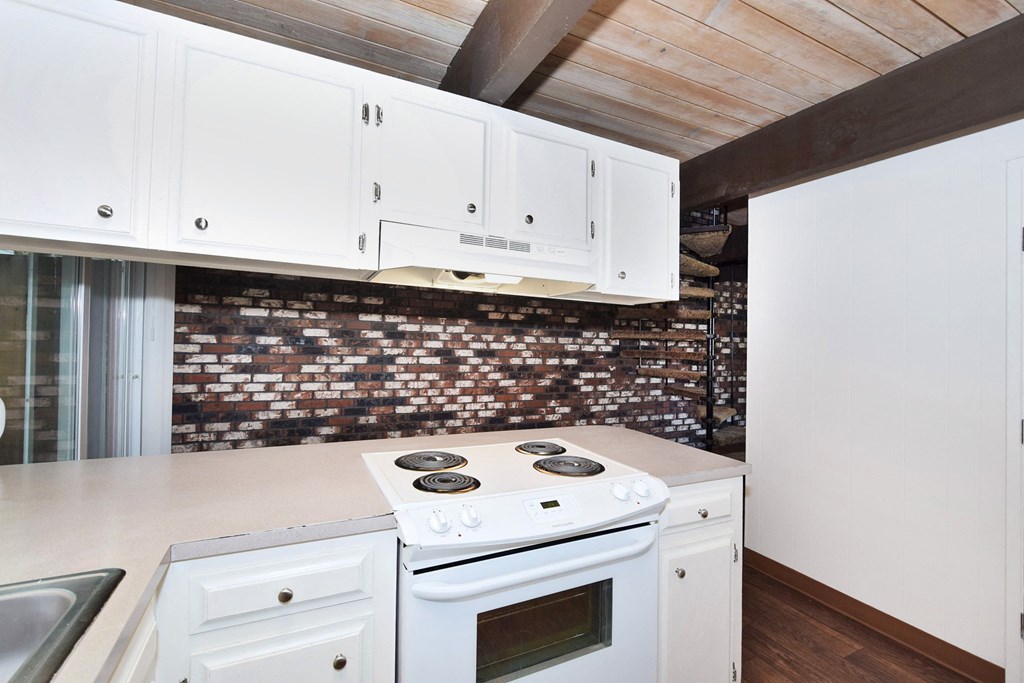 Menlo Manor: kitchen with white cabinets and a white stove top oven