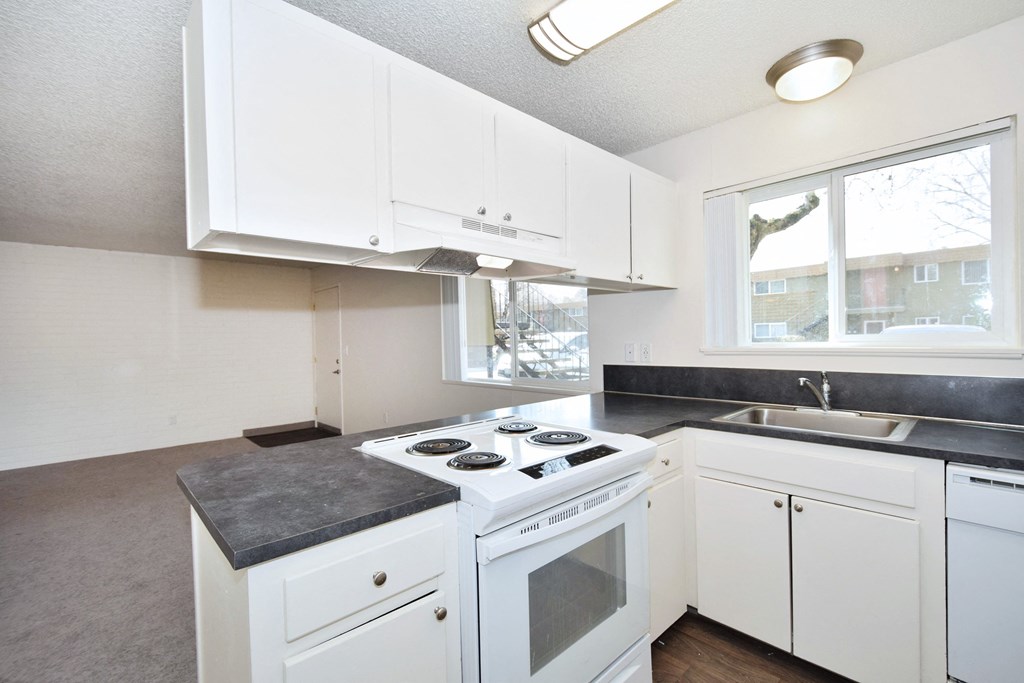 Menlo Manor: kitchen with white cabinets and a white stove top oven
