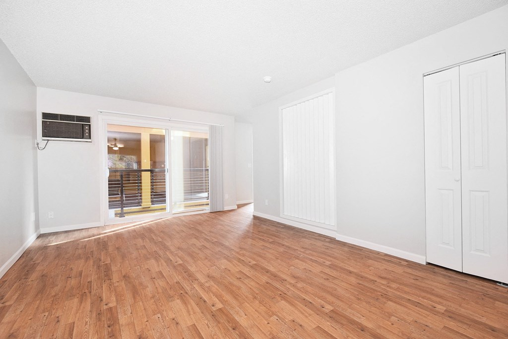 a bedroom with hardwood floors and white walls