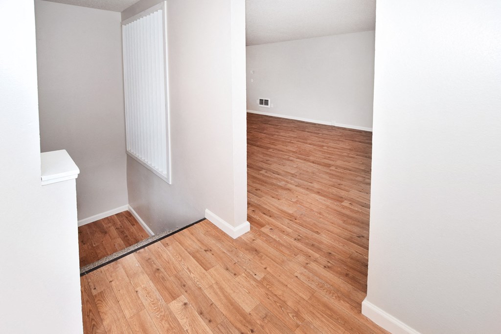 a bedroom with hardwood flooring and white walls