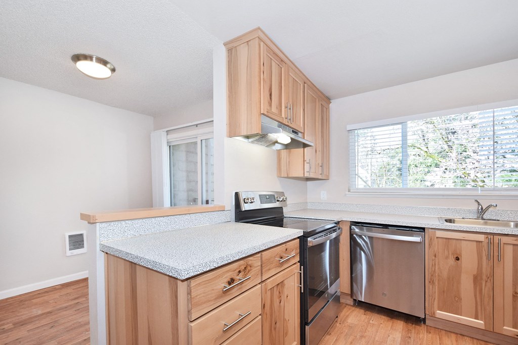 a kitchen with wood cabinets and white countertops