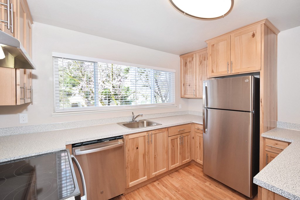 a kitchen with wooden cabinets and a stainless steel refrigerator