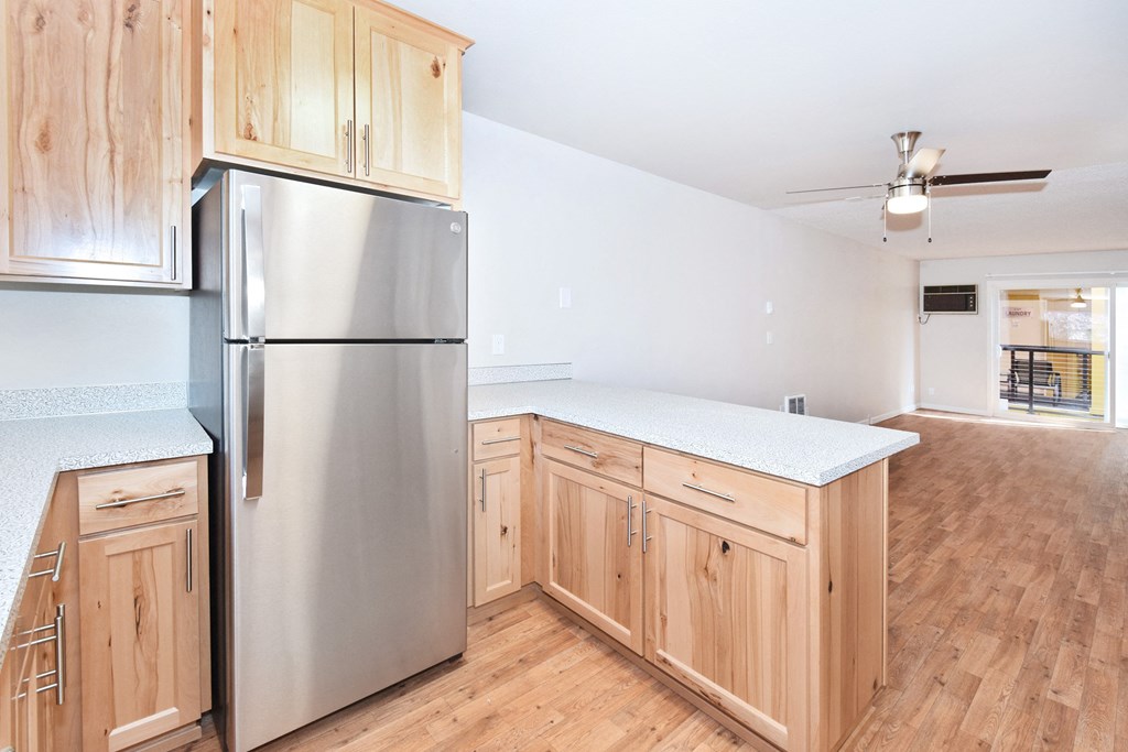a kitchen with wooden cabinets and a stainless steel refrigerator