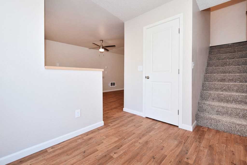 a living room with hardwood floors and a ceiling fan