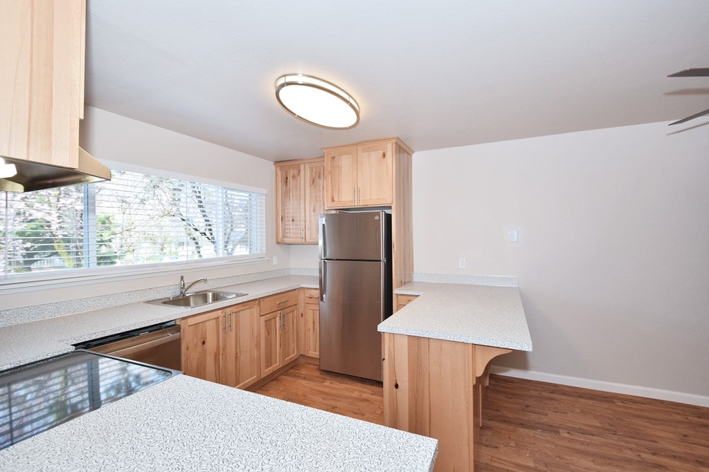 a kitchen with wood flooring and white countertops