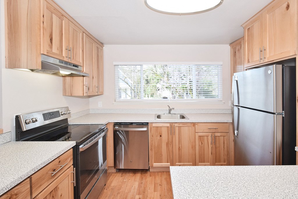 a kitchen with wood cabinets and white countertops