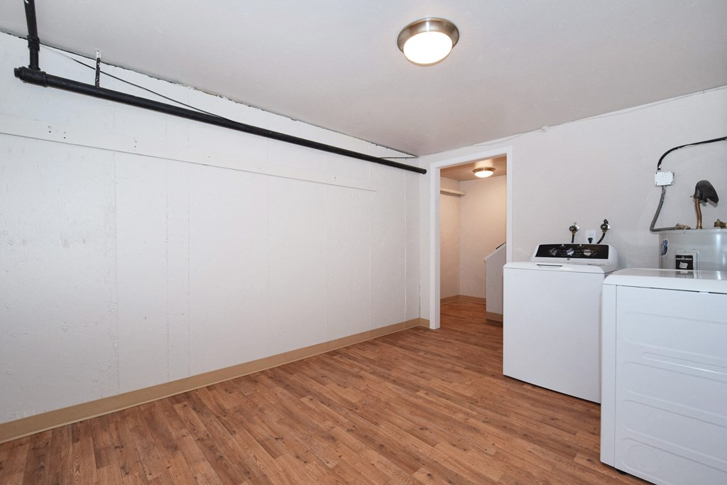 20th and Brooklyn  a kitchen and laundry room with white walls and wood floors