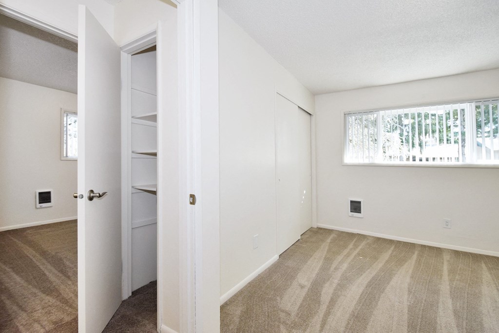 a bedroom with white walls and carpet