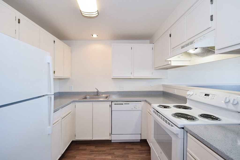 a kitchen with white cabinets and white appliances