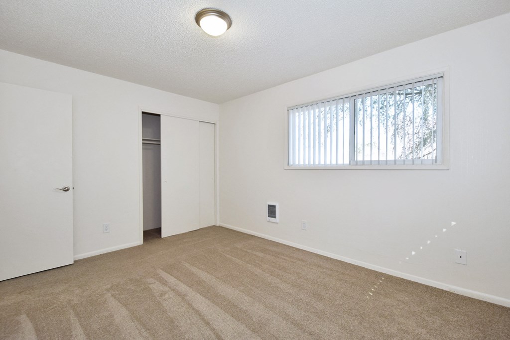 a bedroom with white walls and carpet