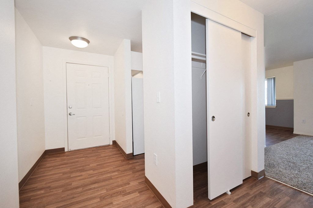 a bedroom with a medium hardwood floor and white walls