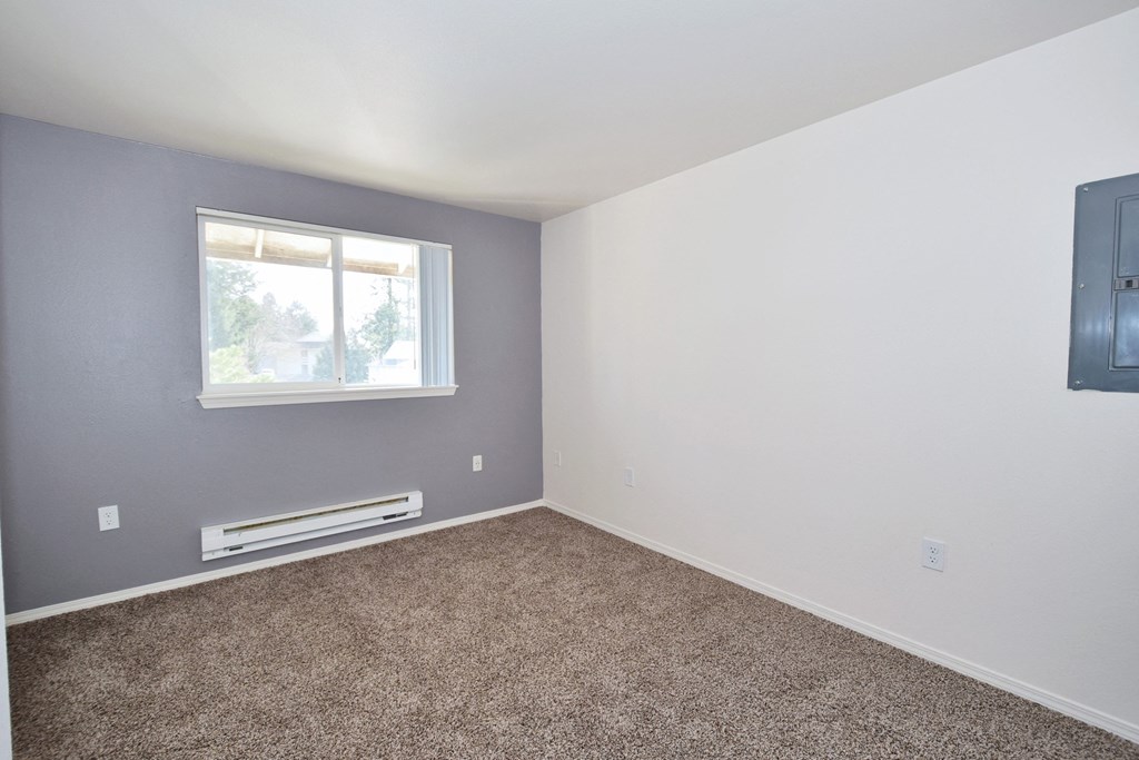an empty room with a window and a radiator