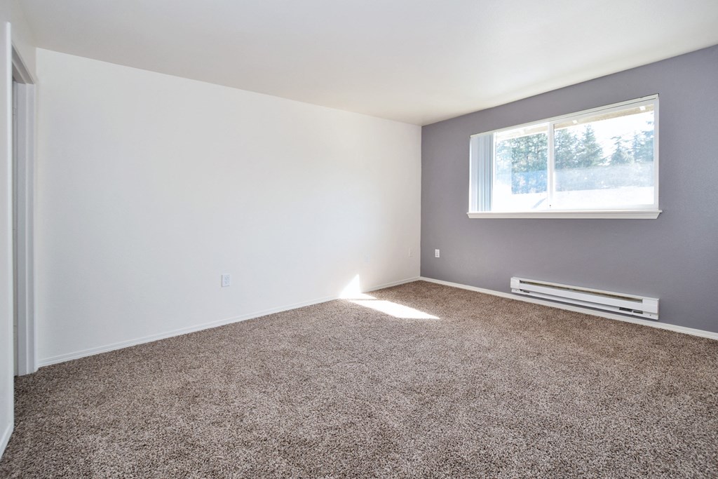 a bedroom with a carpeted floor and a window