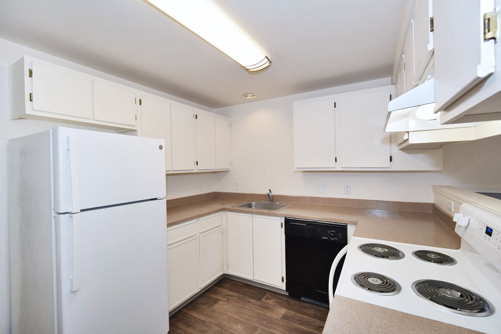 a kitchen with white cabinets and white appliances