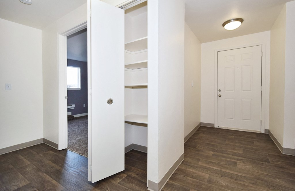 a bedroom with a medium hardwood floor and white walls