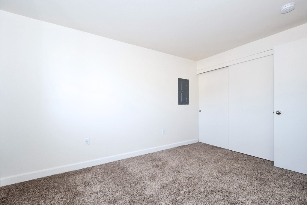 a bedroom with white walls and carpet