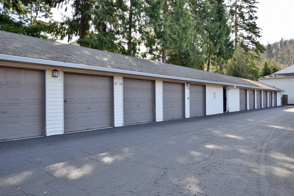 a row of three car garages in a row with trees in the background