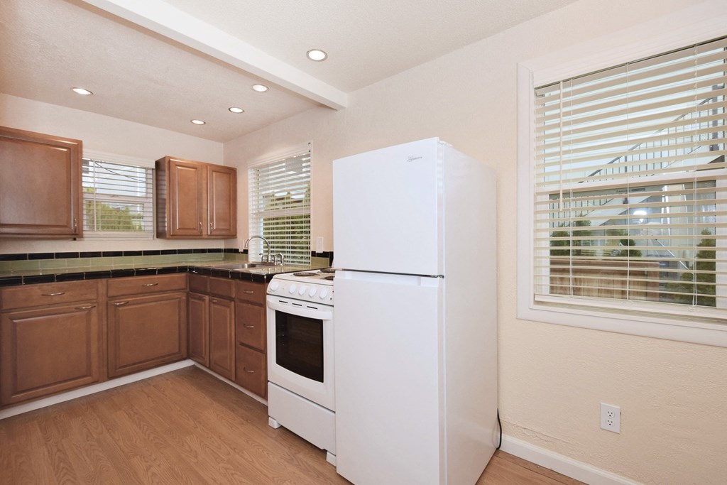 a kitchen with a white refrigerator and stove and wooden cabinets
