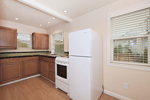 a kitchen with a white refrigerator and stove and wooden cabinets