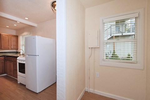 a kitchen with a white refrigerator and a window