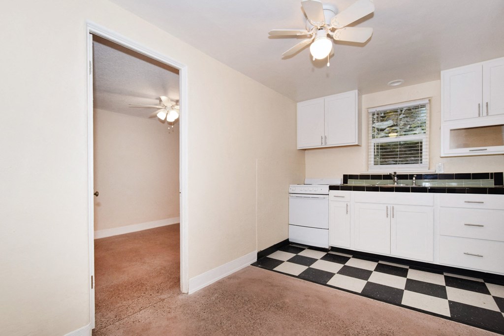 a kitchen with white cabinets and a black and white checkered floor