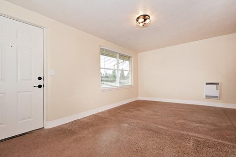 an empty living room with carpet and a white door