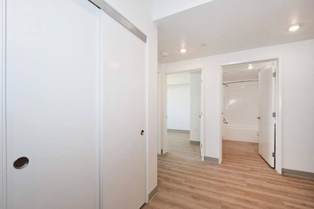 a bedroom with a medium hardwood floor and white walls