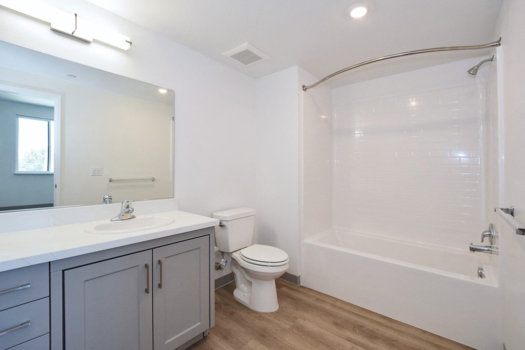 a bathroom with a white sink and toilet next to a white bathtub with a shower curtain